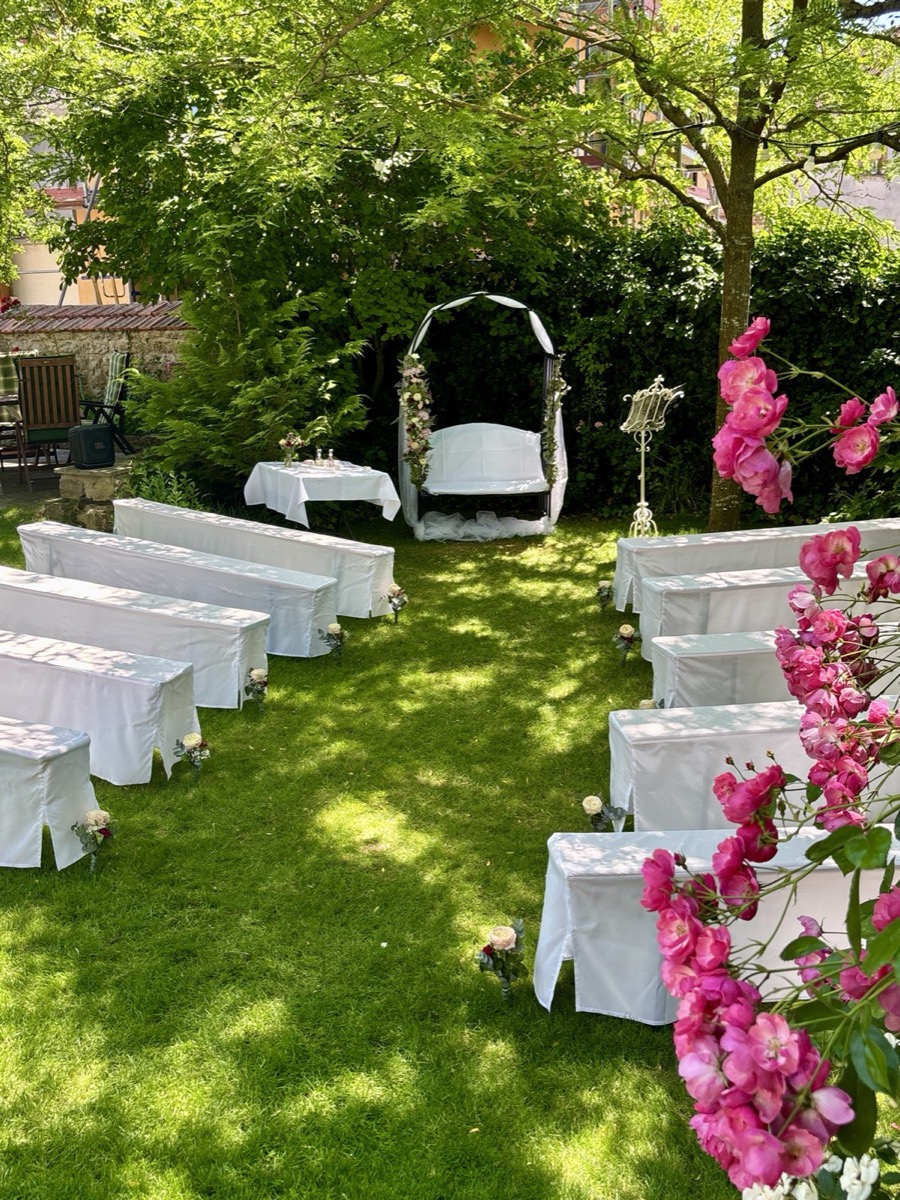 Bestuhlung im Garten mit Blick auf den Traubogen einer freien Trauung